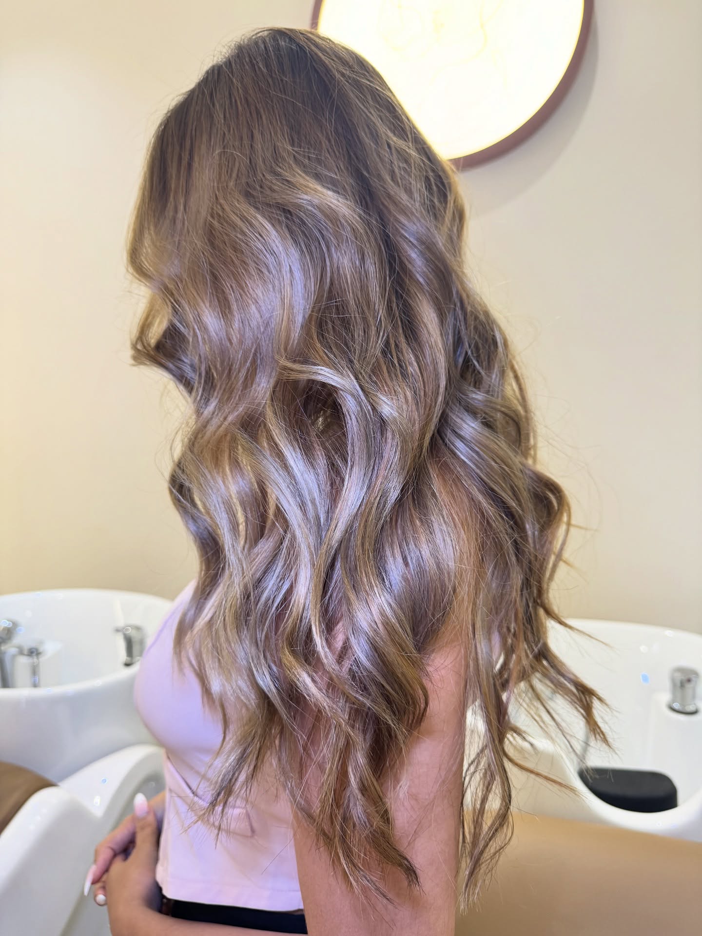 Balayage hair coloring result with natural wavy brunette tones at Lioness Beauty Salon Dubai